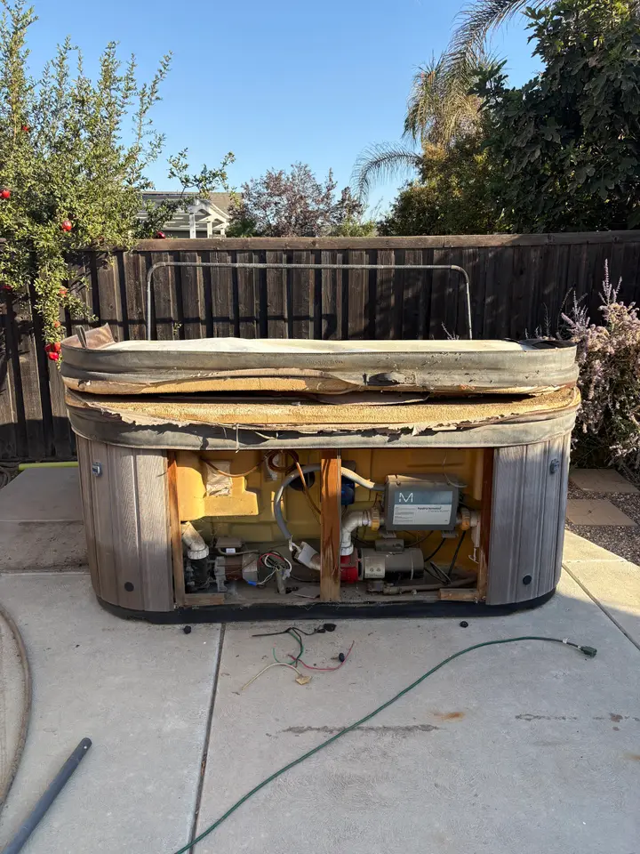 Old hot tub on a backyard patio before removal