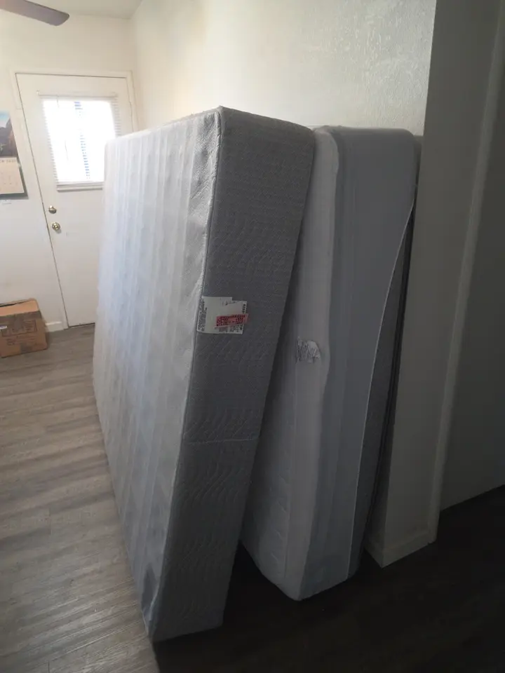 Mattress and box spring waiting for pickup inside a home