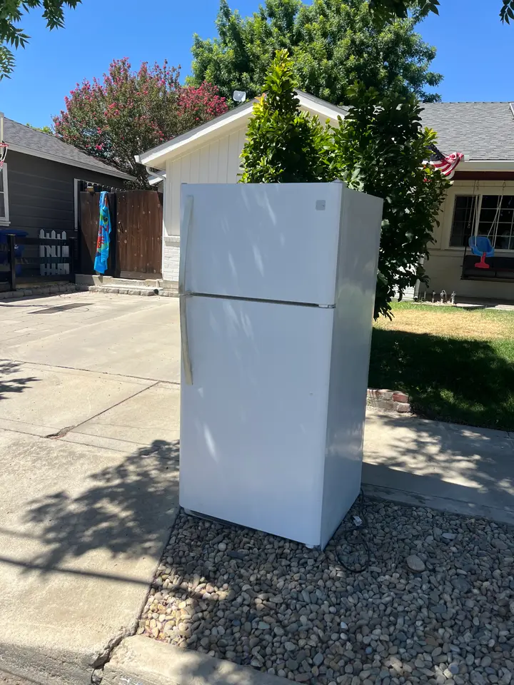 Old refrigerator on a driveway ready for pickup